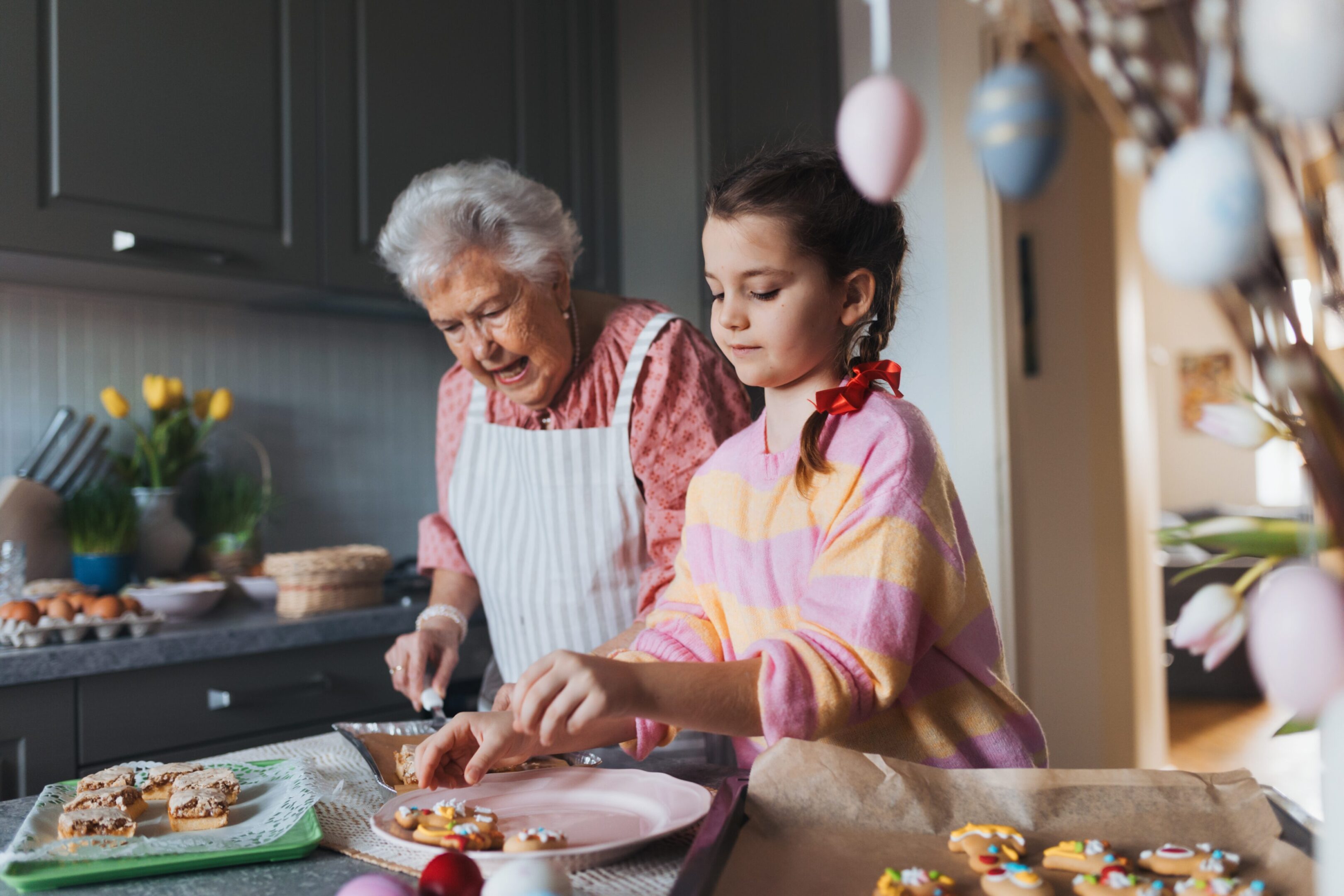 A grandmother and granddaughter cooking together in the kitchen.
